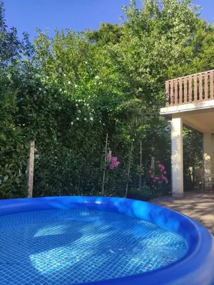 a blue swimming pool in a yard with trees at Šumska Oaza in Laktaši
