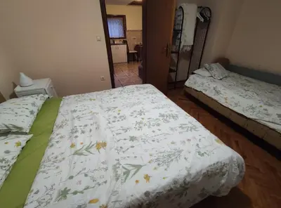 a bedroom with two beds with a floral bedspread at Šumska Oaza in Laktaši