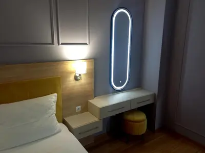 a bedroom with a bed and a vanity with a mirror at MN apartman in Banja Luka