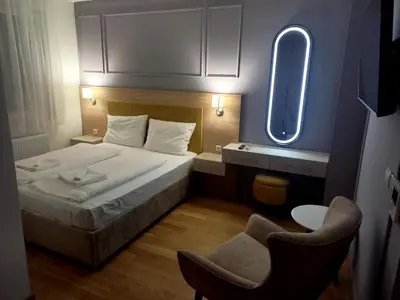 a small bedroom with a bed and a chair at MN apartman in Banja Luka