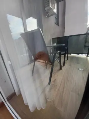 a chair sitting in front of a glass table at MN apartman in Banja Luka