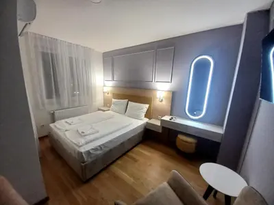 a small hotel room with a bed and a window at MN apartman in Banja Luka