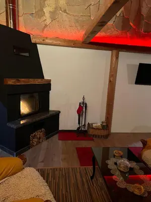 a living room with a fireplace and a table at Dragon's Lodge in Visoko