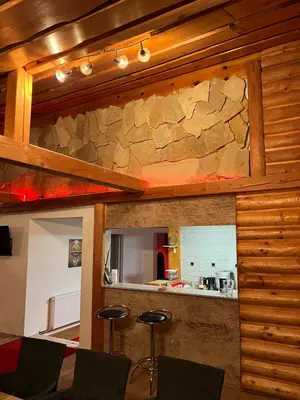 a room with a stone wall and two bar stools at Dragon's Lodge in Visoko