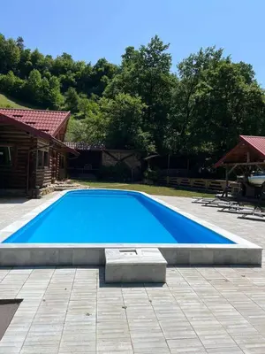 a large blue swimming pool in a yard at Dragon's Lodge in Visoko