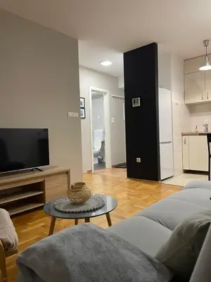 a living room with a couch and a tv and a table at Evergrey in Banja Luka