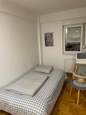 a bedroom with a bed and a table and a window at Evergrey in Banja Luka