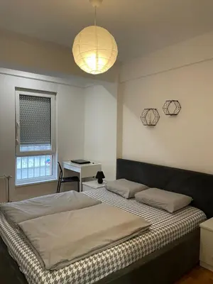 a bedroom with a bed and a desk and a lamp at Evergrey in Banja Luka
