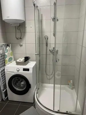 a shower stall in a bathroom with a washing machine at Evergrey in Banja Luka