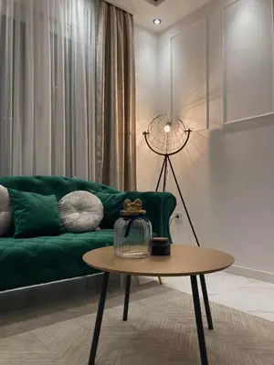 a living room with a green couch and a table at Apartman Atrium Banja Luka in Banja Luka