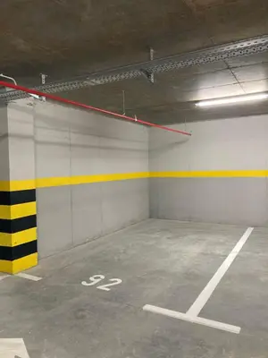 an empty parking garage with a yellow and white wall at Apartman Atrium Banja Luka in Banja Luka