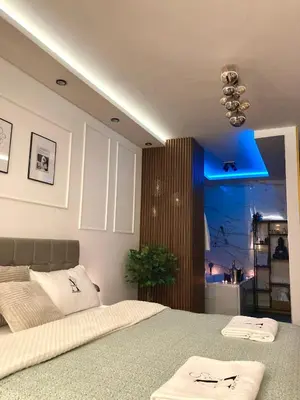 a bedroom with a bed with a blue light at Apartman Atrium Banja Luka in Banja Luka