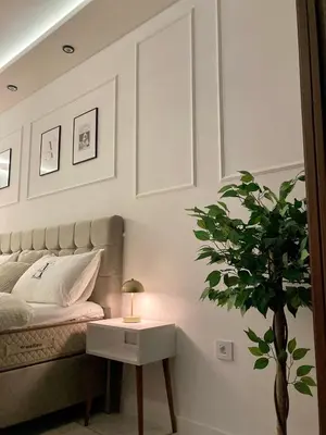 a bedroom with a bed and a table with a plant at Apartman Atrium Banja Luka in Banja Luka