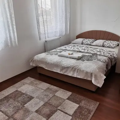 a bedroom with two beds and a rug at Apartman Anja in Banja Luka