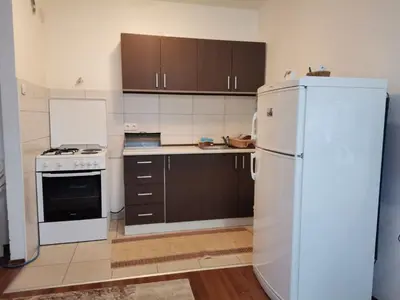 a kitchen with a white refrigerator and brown cabinets at Apartman Anja in Banja Luka