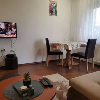 a living room with a table and chairs and a tv at Apartman Anja in Banja Luka