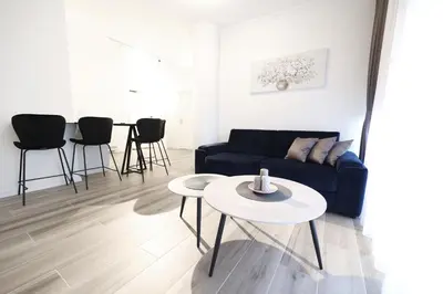 a living room with a blue couch and a table at Central Point Apartmani, Banja Luka in Banja Luka