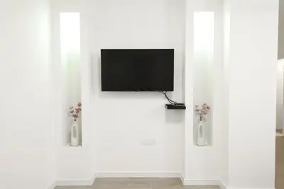 a white wall with two vases with flowers in them at Central Point Apartmani, Banja Luka in Banja Luka