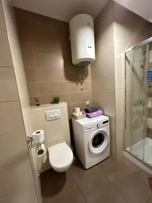 a bathroom with a toilet and a washing machine at Apartmani Kastel 3 in Banja Luka