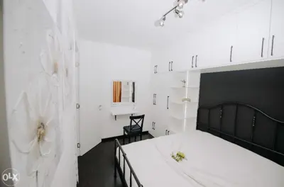 a bedroom with a white bed with a black headboard at Apartmani Kastel 4 in Hiseti