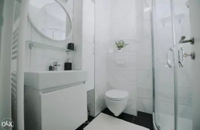 a white bathroom with a toilet and a glass shower at Apartmani Kastel 4 in Hiseti