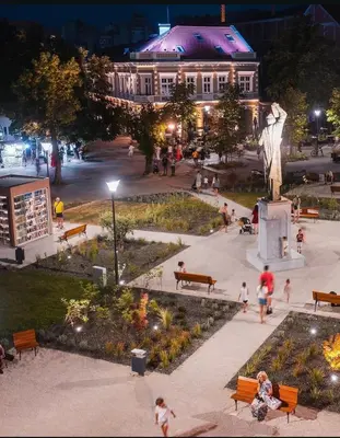 a group of people walking around a park at night at Apartmani Kastel 4 in Hiseti