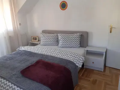 a small bedroom with a bed and two tables at Komforni Apartmani Banja Luka in Banja Luka