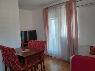 a living room with a table and chairs and a television at Komforni Apartmani Banja Luka in Banja Luka