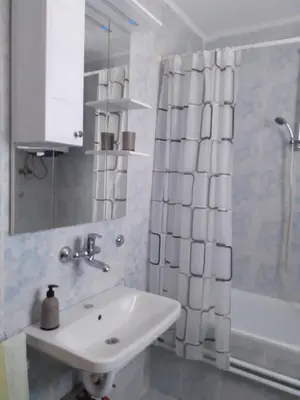 a bathroom with a sink and a shower curtain at Komforni Apartmani Banja Luka in Banja Luka
