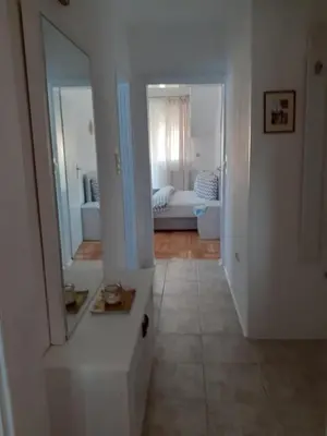 a hallway with a mirror and a living room at Komforni Apartmani Banja Luka in Banja Luka