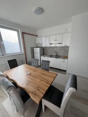 a dining room with a wooden table and chairs at Stan na dan GlobusMG in Mrkonjić Grad