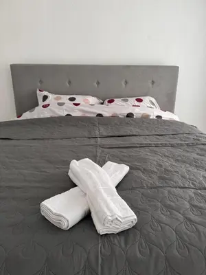 a bed with two white towels on top of it at Stan na dan GlobusMG in Mrkonjić Grad