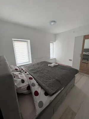 a bedroom with a large bed with a gray comforter at Stan na dan GlobusMG in Mrkonjić Grad