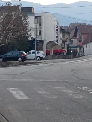 an empty street with cars parked in front of a building at Stan na dan GlobusMG in Mrkonjić Grad