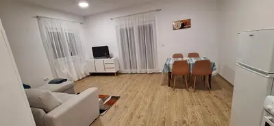 a living room with a table and chairs and a couch at Stan Banja Luka Paprikovac in Banja Luka