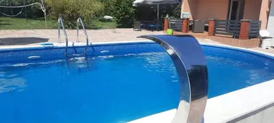 a blue swimming pool with two swings at Holiday home Alexa in Banja Luka