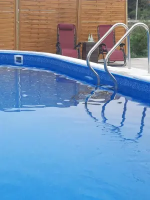 a swimming pool with two chairs sitting next to it at Holiday home Alexa in Banja Luka