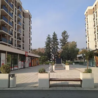 a park with a bench in front of a building at Apartman Doboj in Doboj