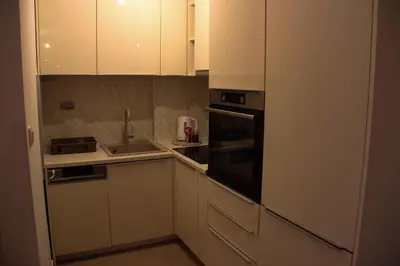 a kitchen with white cabinets and a sink and a stove at Apartman Doboj in Doboj