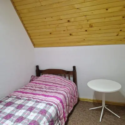 a small bedroom with a bed and a table at Endzi VS Vlašić in Travnik