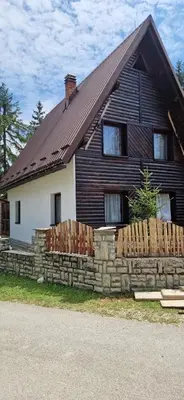 a house with a stone fence in front of it at Endzi VS Vlašić in Travnik