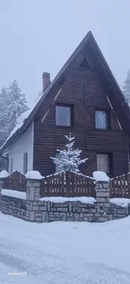 a log house with a fence in the snow at Endzi VS Vlašić in Travnik