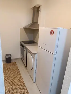 a small kitchen with a refrigerator and a stove at Apartman Bulevar Živinice in Živinice