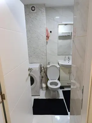 a small bathroom with a toilet and a sink at Apartman Bulevar Živinice in Živinice