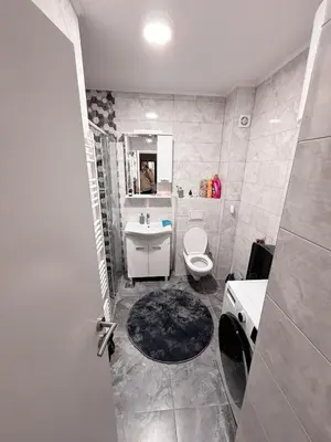 a bathroom with a toilet and a sink and a mirror at Apartment Saturday in Travnik