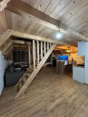 a living room with a wooden staircase in a house at Planinska kuća Rea, Vlašić in Vlasic