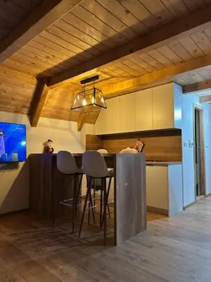 a kitchen with a table and two stools at Planinska kuća Rea, Vlašić in Vlasic
