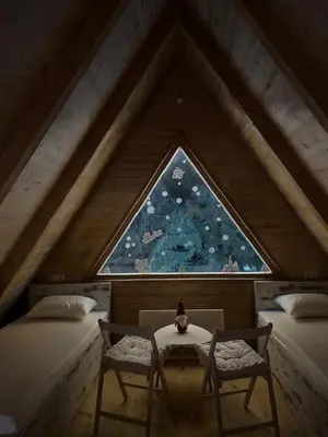 a attic room with two beds and a window at Planinska kuća Rea, Vlašić in Vlasic