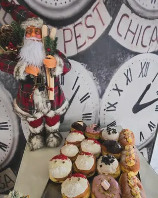 a santa clause standing next to a table of pastries at Apartment 27 small in Banja Luka