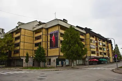 a large yellow building with a large ad on it at Apartment 27 small in Banja Luka